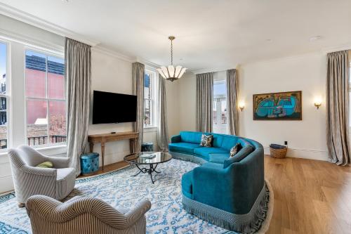 a living room with a blue couch and a tv at Hotel Perle in New Orleans