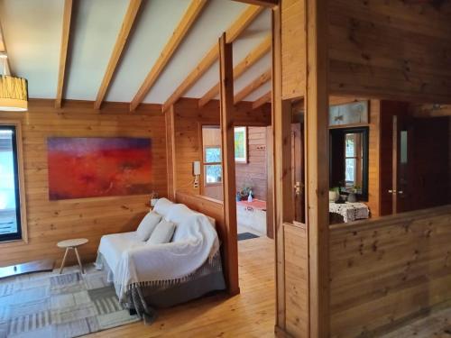 a living room with a bed in a room with wooden walls at Raki Bed and Breakfast Hostel in Trape