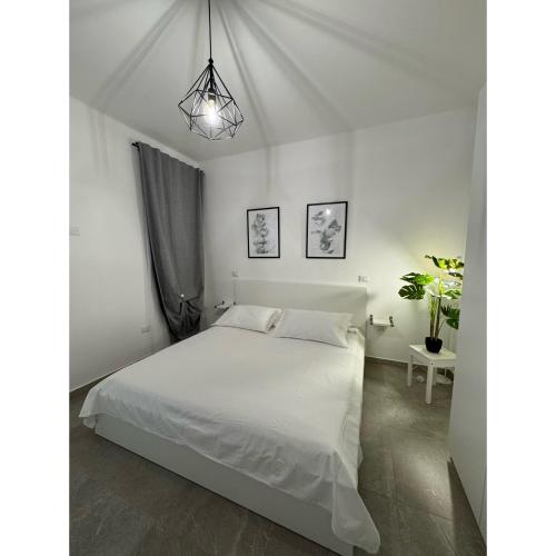 a bedroom with a white bed and a potted plant at Salento Apartment in Brindisi