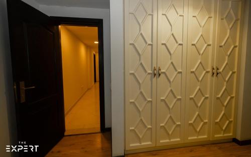 a corridor with a door with a hallway leading to a room at The Expert in Ocean Blue Near Airport in Cairo