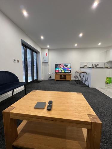 a living room with a coffee table and a tv at The Homely Retreat Spacious Ground Floor Flat Near Oxford City Centre, Free Parking in Oxford