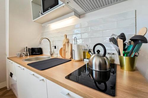 - un comptoir de cuisine avec une bouilloire et une cuisinière dans l'établissement La Canopée - calme au coeur de Fougères, à Fougères