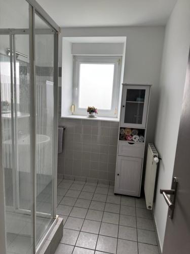 une salle de bain avec une douche et un lavabo et une fenêtre dans l'établissement Charmante maison en pierre, à Saint-Eutrope