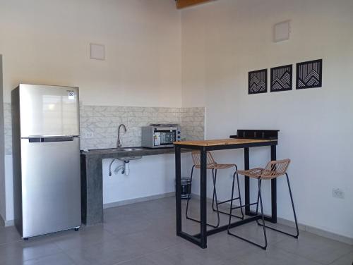 una cucina con frigorifero, tavolo e sedie di Vistas de Victoria - Potrero de los Funes a Potrero de los Funes