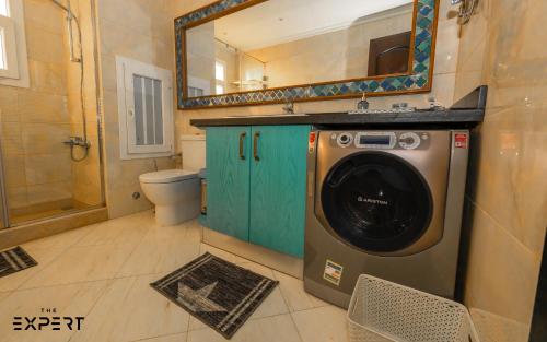 a washing machine in a bathroom with a mirror at The Expert in Ocean Blue Near Airport in Cairo