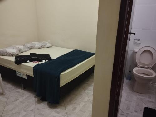 a small bedroom with a bed and a toilet at Grussaí houses in São João da Barra