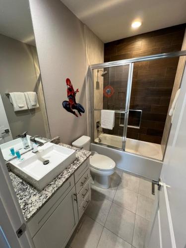 a bathroom with a sink and a toilet and a shower at Disney here we go in Orlando