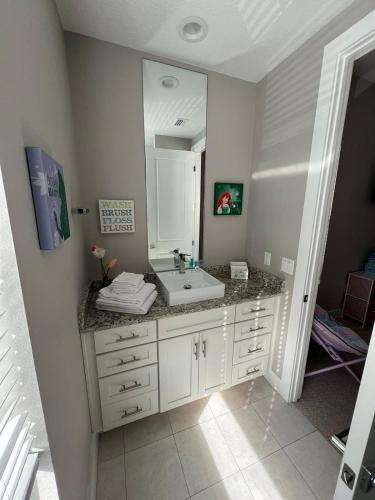 a bathroom with a sink and a mirror at Disney here we go in Orlando