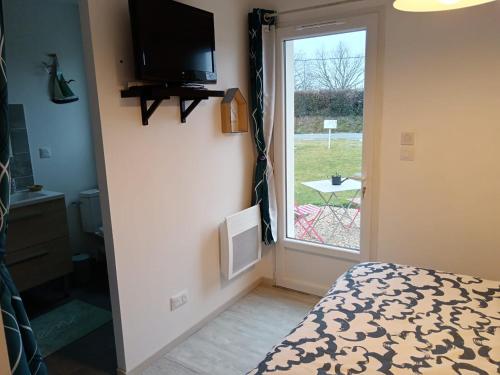 une chambre avec un lit, une télévision et une fenêtre dans l'établissement Les hortensias, à Soubran