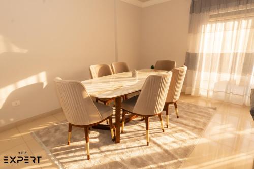 a dining room with a wooden table and chairs at The Expert in Ocean Blue Near Airport in Cairo