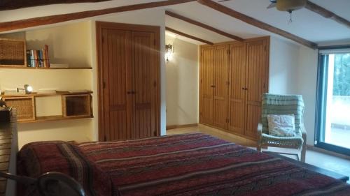 una camera da letto con un letto, una sedia e una finestra di El Balcón de la Sierra a Cazorla