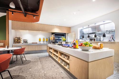 a kitchen with a counter with a bowl of fruit on it at Holiday Inn Dandenong by IHG in Dandenong