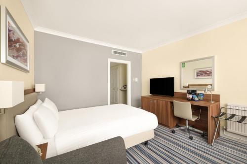 a hotel room with a bed and a desk and a computer at Holiday Inn York by IHG in York