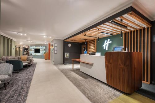 an office lobby with a reception desk and chairs at Holiday Inn York by IHG in York