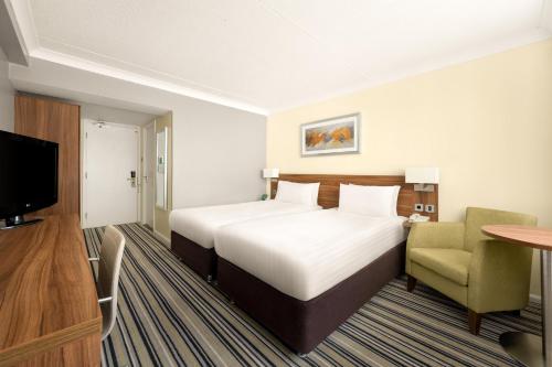 a hotel room with a large bed and a chair at Holiday Inn York by IHG in York