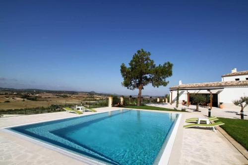 a swimming pool with chairs and a house at Mater Ariany in Ariany