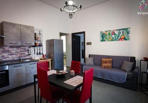 a kitchen and a living room with a table and a couch at Siculea Home in Adrano