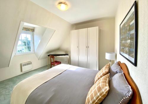 a bedroom with a bed and a window at Duplex Bellevue, vue mer, à 50m de la plage! in Réville