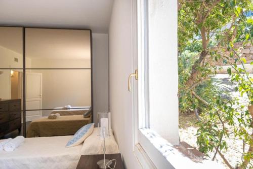 a bedroom with a mirror and a bed with a window at Orizzonte Blu 103 in Liscia di Vacca