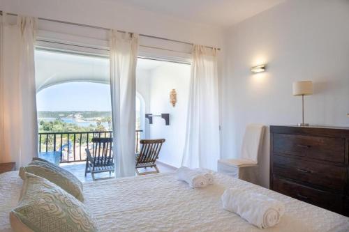 a bedroom with a bed with a view of a balcony at Orizzonte Blu 103 in Liscia di Vacca