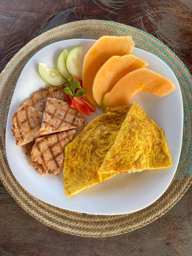 a white plate of food with omelets and other foods at Palaa Mayapo Ecolodge in Mayapo