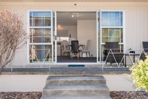 
a room with a table, chairs and a door at Te Tiriti Units in Paihia

