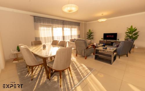 a dining room and living room with a table and chairs at The Expert in Ocean Blue Near Airport in Cairo