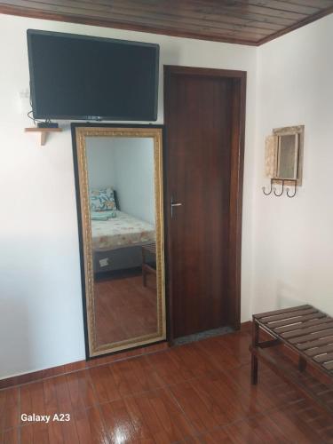 a mirror in a room with a bedroom with a bed at Morada do Sabiá in Resende