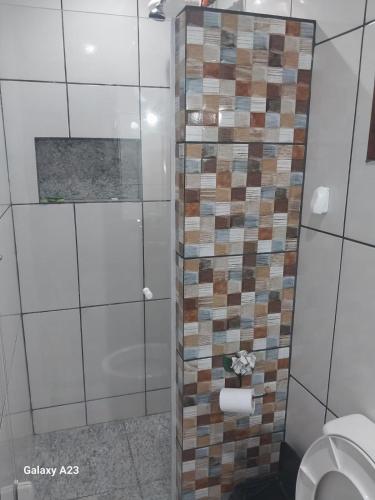 a bathroom with a toilet and a tiled wall at Morada do Sabiá in Resende