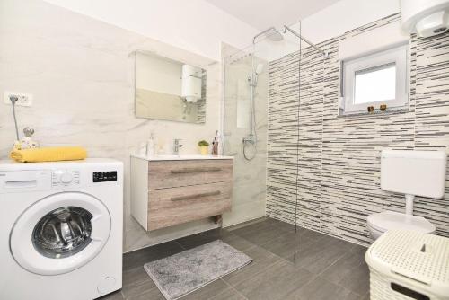 a bathroom with a washing machine and a sink at Apartment Gordana Mar in Vrsi