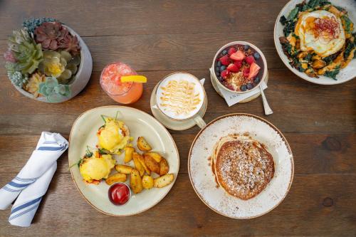 a table with plates of food and bowls of food at Andaz San Diego, By Hyatt in San Diego