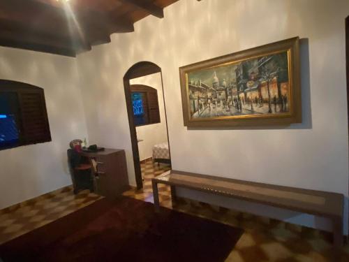 a room with a painting on the wall and a mirror at Casa na Carioca em Goias Velho in Goiás