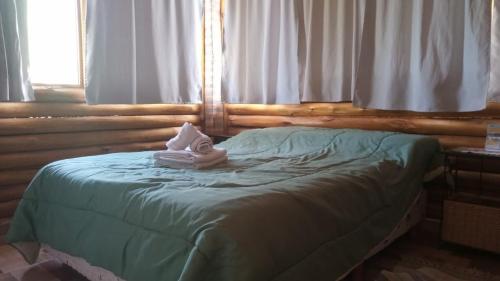 a bed with a towel on it in a bedroom at Aimara Casas de alquiler in Mina Clavero
