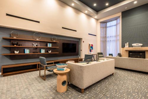 a living room with a couch and a flat screen tv at Sonesta Select Dallas Richardson in Richardson