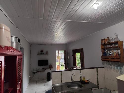 a kitchen with a sink and a tv on the ceiling at Casa Praia Reserva - Casa Completa no Paraíso in Aracruz