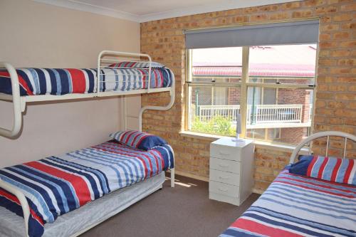 Dos literas en una habitación con ventana. en Ocean Shores Apartment 05 - Bing your own linen., en South West Rocks