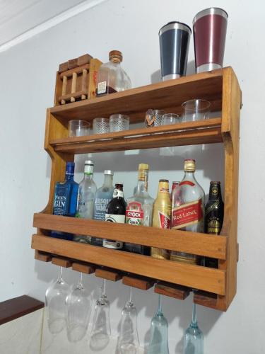 a wooden shelf with bottles and glasses on it at Casa Praia Reserva - Casa Completa no Paraíso in Aracruz