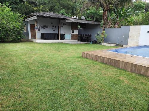 a backyard with a house and a swimming pool at Casa Praia Reserva - Casa Completa no Paraíso in Aracruz