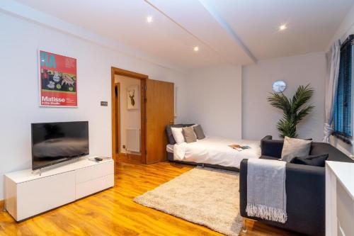 a living room with a bed and a tv at Buckingham Suite - Heart of Covent Garden! in London
