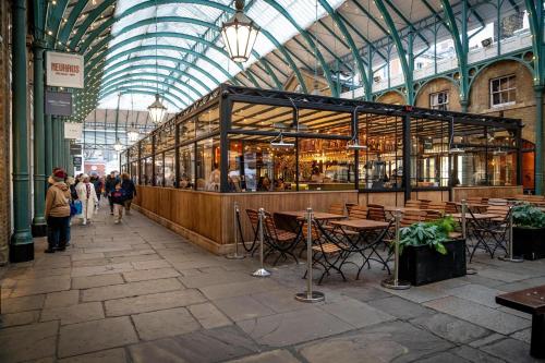 a restaurant in a building with tables and chairs at Buckingham Suite - Heart of Covent Garden! in London