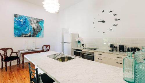a kitchen with a counter and a sink and a refrigerator at The Manor Apartments in Port Lincoln