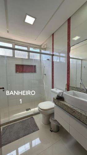 a bathroom with a toilet and a sink at PERFEITO!!! Apartamento de 3 quartos com ar-condicionado a 30 metros da Praia do Morro in Guarapari