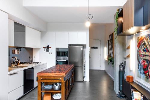 a kitchen with white cabinets and a stainless steel refrigerator at Welcome To Casa de Richmond in Melbourne