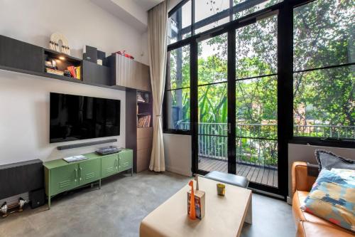 a living room with a tv and large windows at Welcome To Casa de Richmond in Melbourne