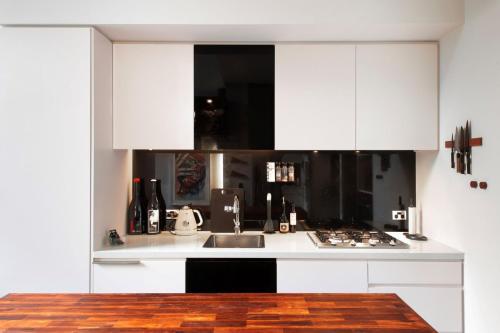 a kitchen with white cabinets and a sink at Welcome To Casa de Richmond in Melbourne