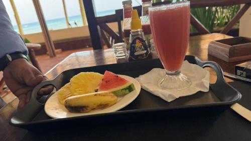 un vassoio con un panino e una bevanda su un tavolo di Blue Tides Hotel a Nungwi