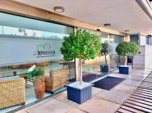 a mall with several potted trees in front of a store at ApartHome Domocenter in Bormujos