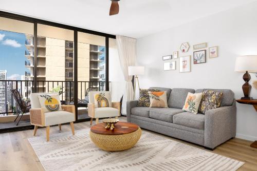 a living room with a couch and chairs and a balcony at Waikiki Banyan Fabulous Ocean View Condo with Free Parking in Honolulu