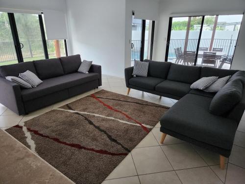 a living room with two couches and a rug at Ocean views in Buddina