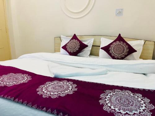 two beds with white sheets and purple pillows at The Hidden Cove in Bhīm Tāl